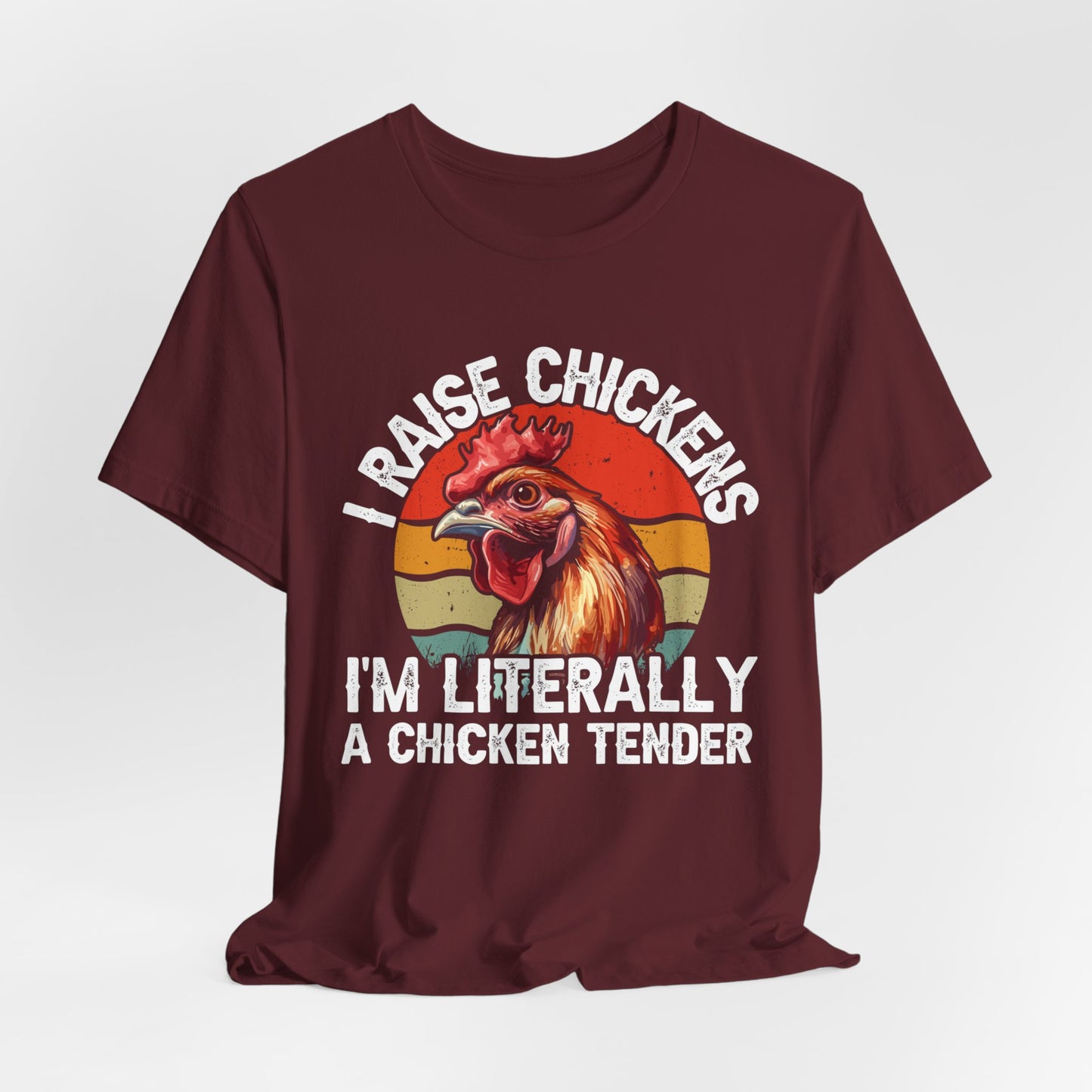 maroon shirt with I raise chickens I'm Literally a chicken tender on the front in distressed print. There is a rooster in the design.