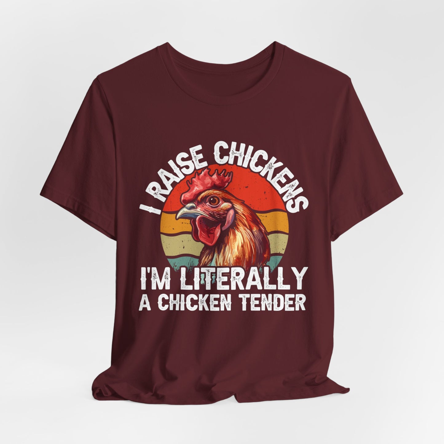 maroon shirt with I raise chickens I'm Literally a chicken tender on the front in distressed print. There is a rooster in the design. 